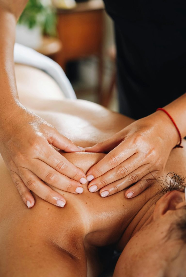 Nackenmassage in Sulzbach Hände massieren den Rücken einer liegenden Person mit Öl.